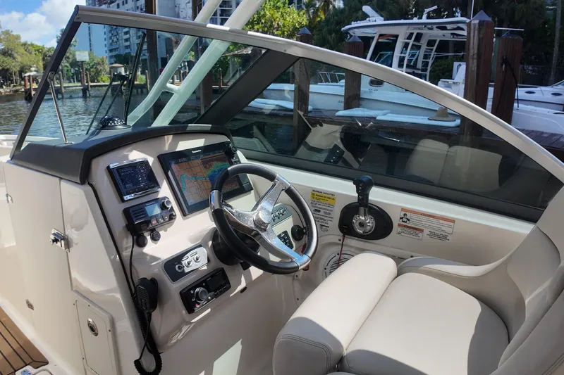 Slide: The Image of 2017 Boston Whaler 230 Vantage boat cockpit with steering wheel and navigation equipment. - 14