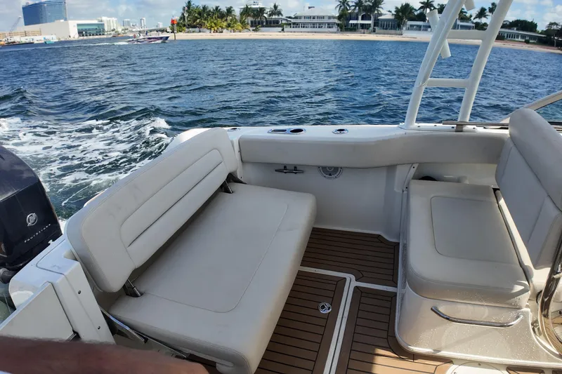 Slide: The Image of 2017 Boston Whaler 230 Vantage interior with seating, on water near a beach. - 17