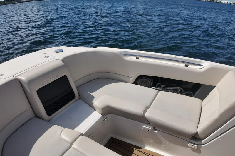 Slide: The Image of 2017 Boston Whaler 230 Vantage boat interior with cushioned seating, on calm water. - 25