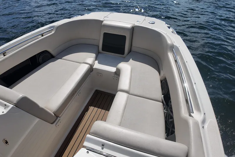 Slide: The Image of 2017 Boston Whaler 230 Vantage boat interior with cushioned seating on the water. - 26