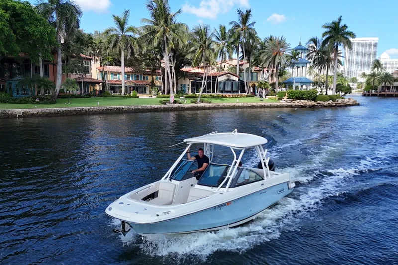 Slide: The Image of 2017 Boston Whaler 230 Vantage cruising near luxurious waterfront homes and palm trees. - 4
