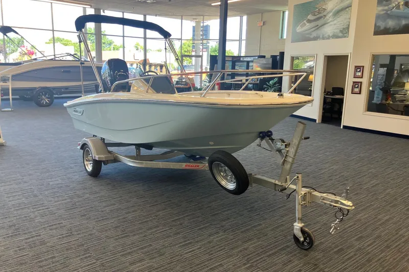 The Image of 2025 Boston Whaler 130 Super Sport boat on trailer in showroom. - 0
