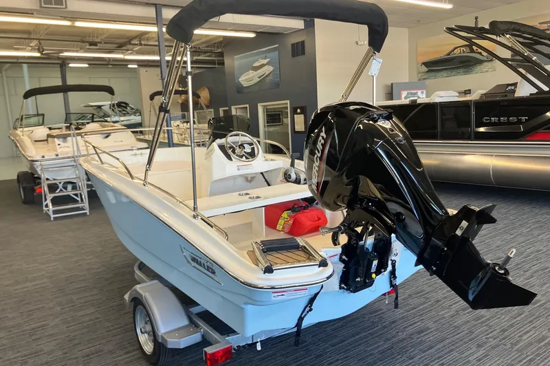 Slide: The Image of 2025 Boston Whaler 130 Super Sport boat with Mercury outboard motor in showroom. - 4