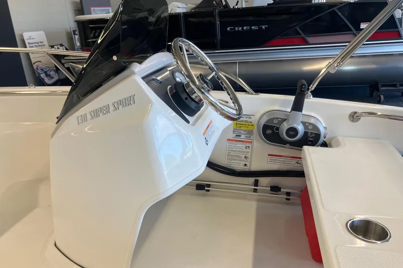 Slide: The Image of 2025 Boston Whaler 130 Super Sport boat interior with steering wheel and controls. - 7