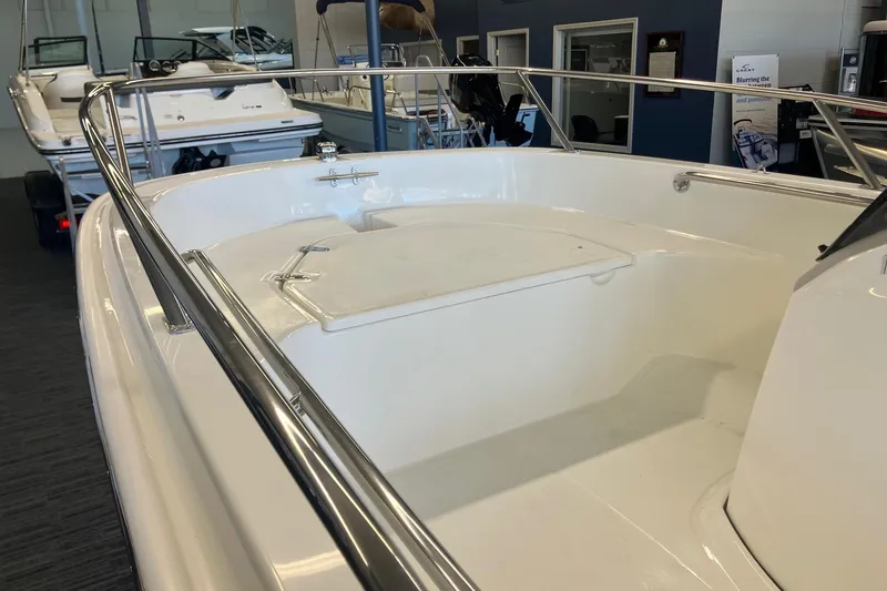 Slide: The Image of 2025 Boston Whaler 130 Super Sport boat interior with sleek design and stainless steel railings. - 8