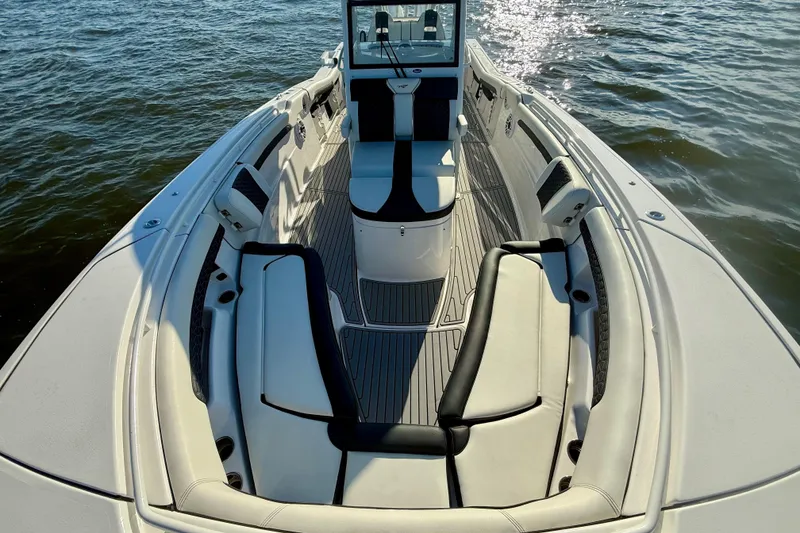 Slide: The Image of 2024 Tidewater 320 CC Adventure boat interior with cushioned seating on open water. - 13