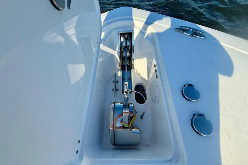 Slide: The Image of 2024 Tidewater 320 CC Adventure boat anchor compartment, featuring sleek design and chrome fittings. - 14