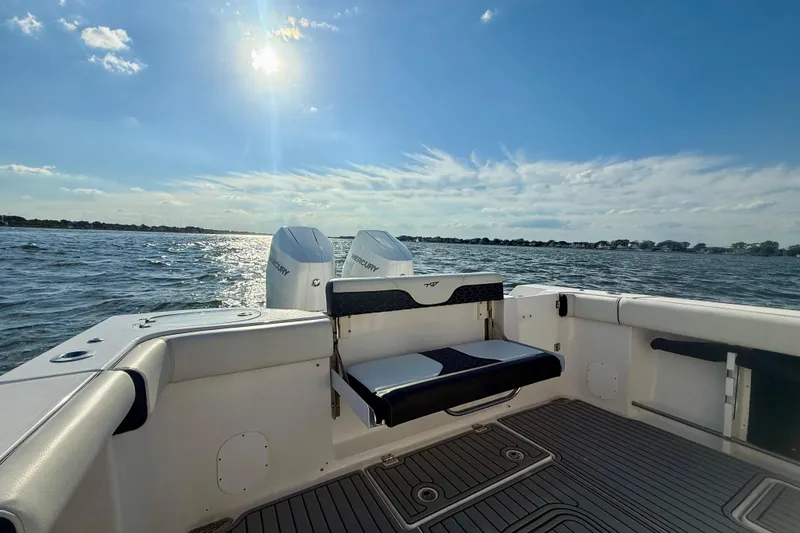 Slide: The Image of 2024 Tidewater 320 CC Adventure boat on water, sunny day, rear seating view. - 23