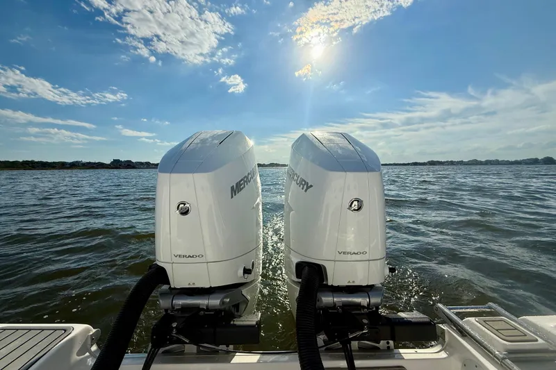 Slide: The Image of Twin Mercury Verado engines on 2024 Tidewater 320 CC Adventure boat under sunny sky. - 25