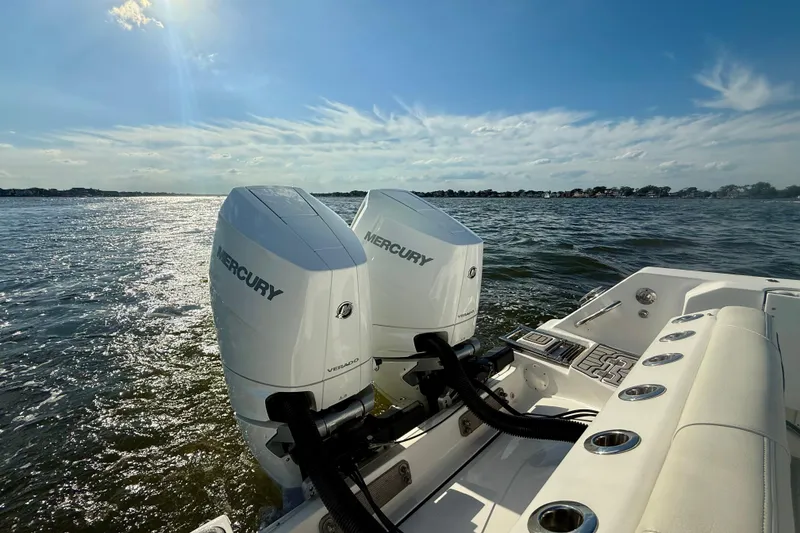 Slide: The Image of 2024 Tidewater 320 CC Adventure boat with dual Mercury engines on a sunny day. - 26