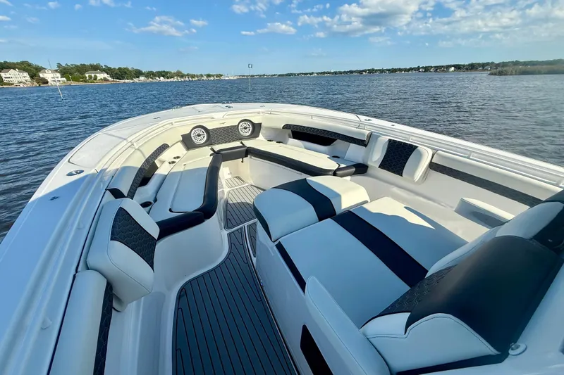 Slide: The Image of 2024 Tidewater 320 CC Adventure boat interior with luxurious seating on a calm lake. - 34