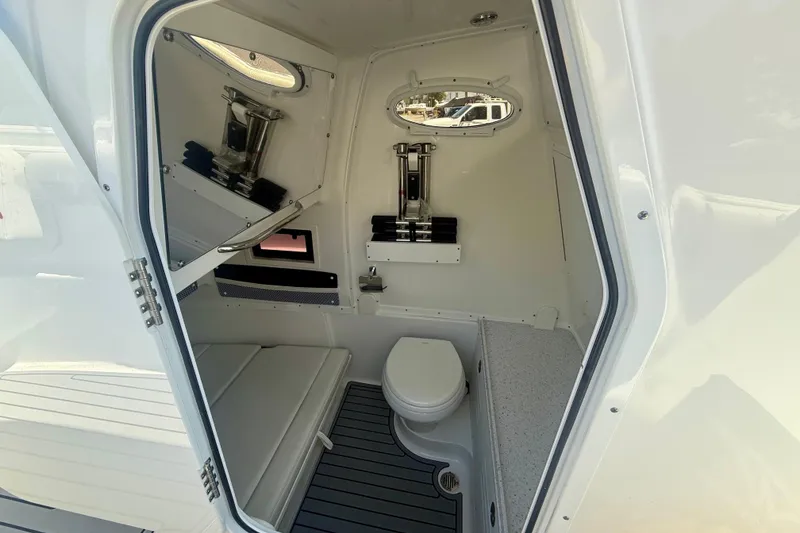Slide: The Image of 2024 Tidewater 320 CC Adventure boat cabin with toilet and seating area. - 38