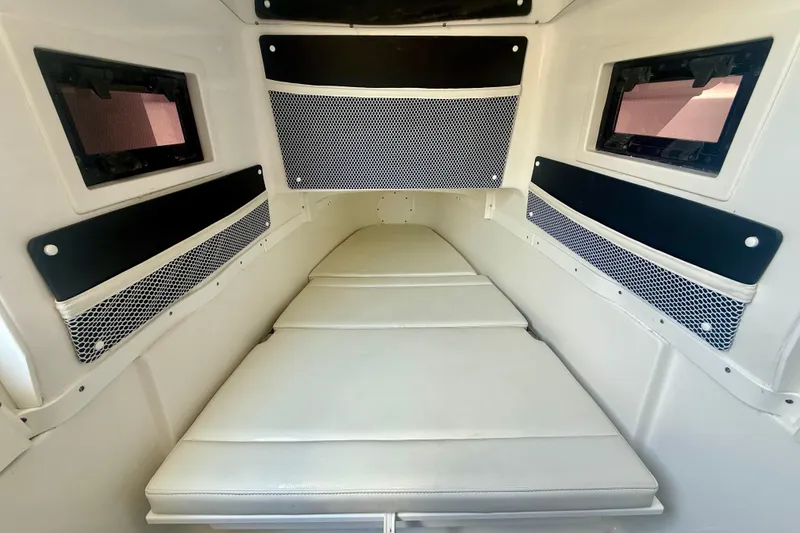 Slide: The Image of 2024 Tidewater 320 CC Adventure cabin interior with cushioned seating and storage nets. - 40
