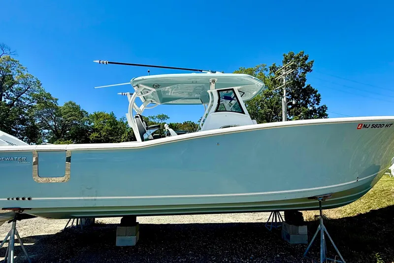 Slide: The Image of 2024 Tidewater 320 CC Adventure boat on stands under clear blue sky. - 5