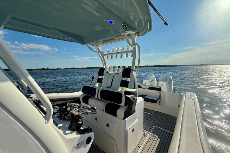 Slide: The Image of 2024 Tidewater 320 CC Adventure boat interior with dual engines on a sunny day. - 6