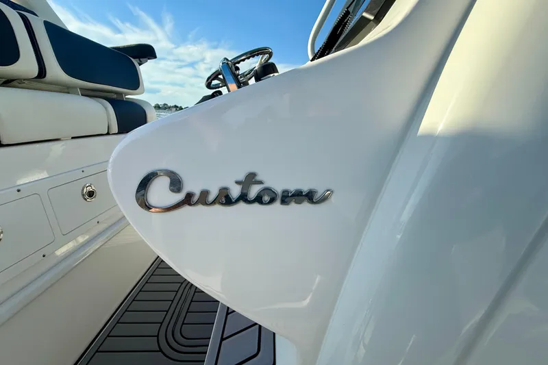 Slide: The Image of 2024 Tidewater 320 CC Adventure boat interior with "Custom" emblem detail. - 7