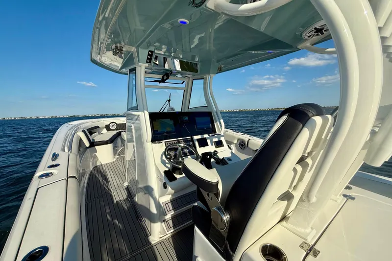 Slide: The Image of 2024 Tidewater 320 CC Adventure boat interior with helm, seats, and ocean view. - 8