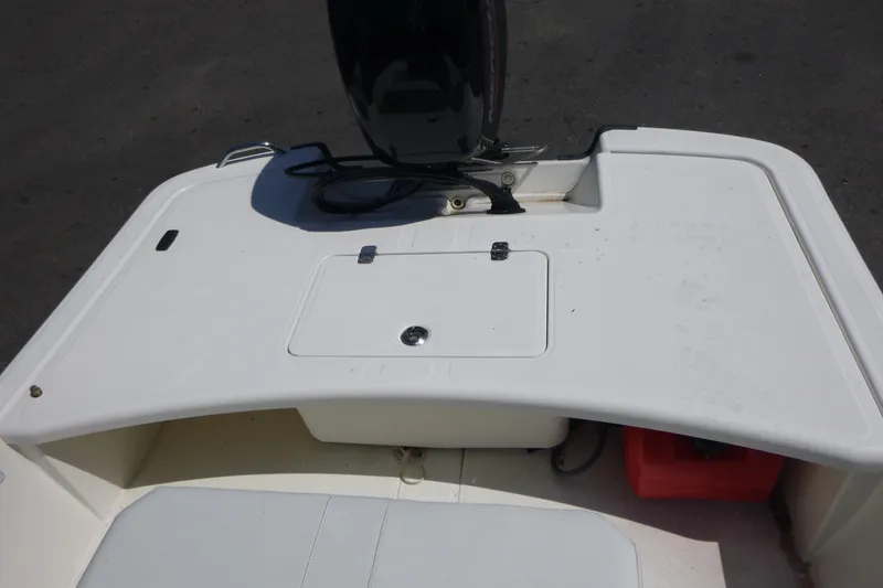 Slide: The Image of 2024 Mako Pro Skiff 17 CC boat deck with storage compartment and motor. - 11