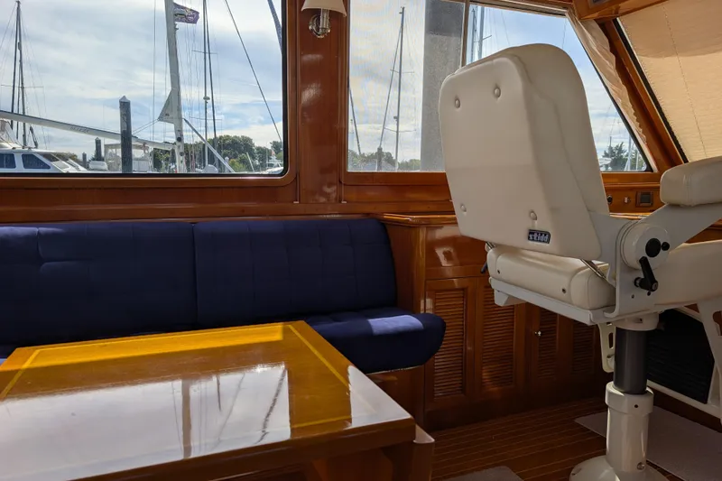 Slide: The Image of Interior of 2006 Grand Banks 49 Eastbay SX yacht with blue seating and wooden table. - 25