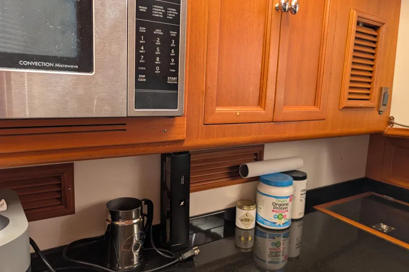 Slide: The Image of Galley kitchen in 2006 Grand Banks 49 Eastbay SX with microwave and wooden cabinets. - 51