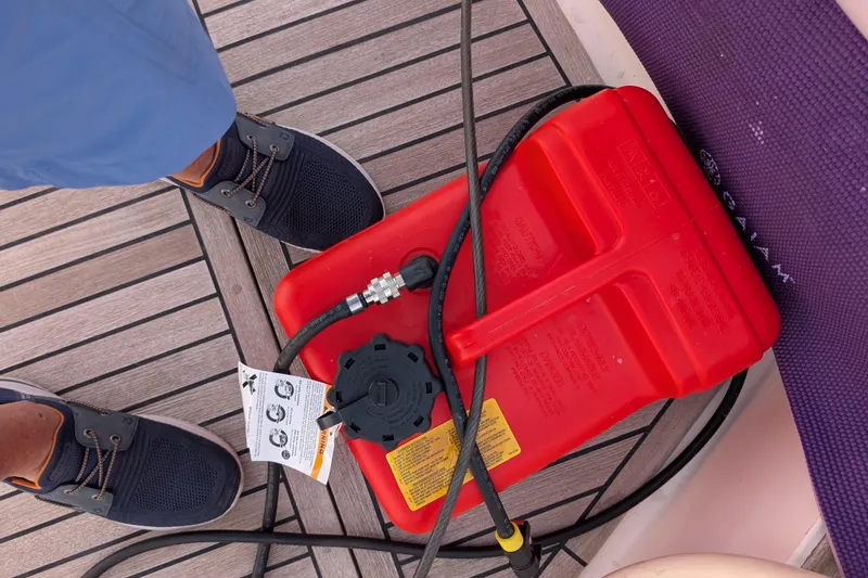 Slide: The Image of Red fuel container on Grand Banks 49 Eastbay SX 2006 deck with hose and shoes visible. - 70