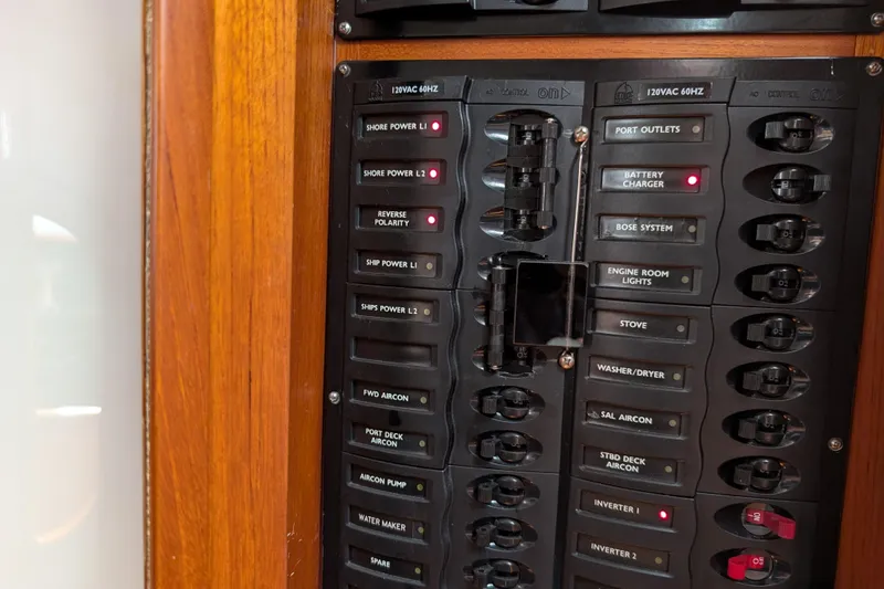Slide: The Image of Electrical panel on a 2006 Grand Banks 49 Eastbay SX yacht, featuring labeled switches and indicators. - 53