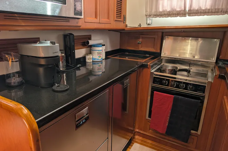 Slide: The Image of Luxurious 2006 Grand Banks 49 Eastbay SX yacht kitchen with modern appliances and wooden cabinetry. - 46