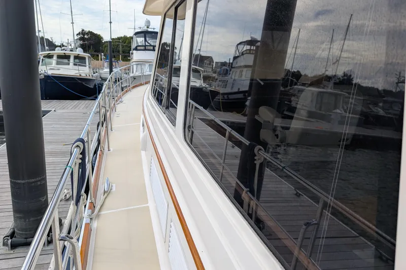 Slide: The Image of 2006 Grand Banks 49 Eastbay SX yacht docked at marina, showcasing sleek design and reflection. - 8