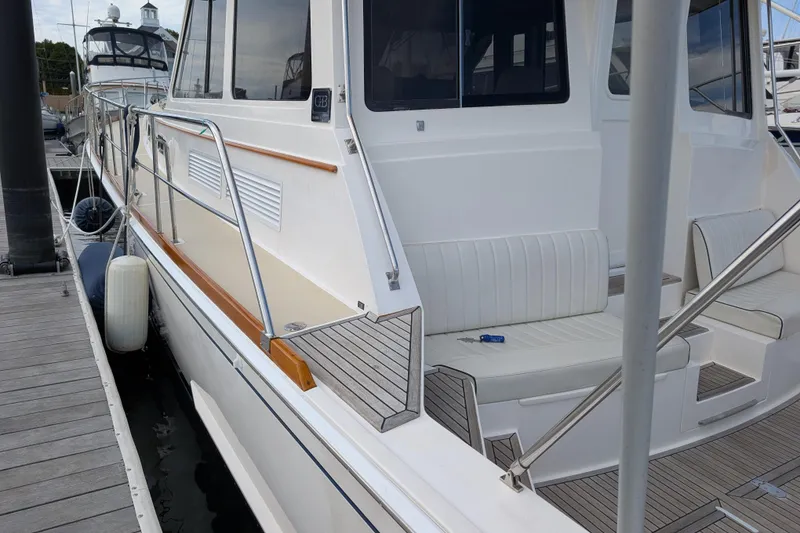 Slide: The Image of 2006 Grand Banks 49 Eastbay SX yacht docked, featuring sleek white exterior and comfortable seating. - 12