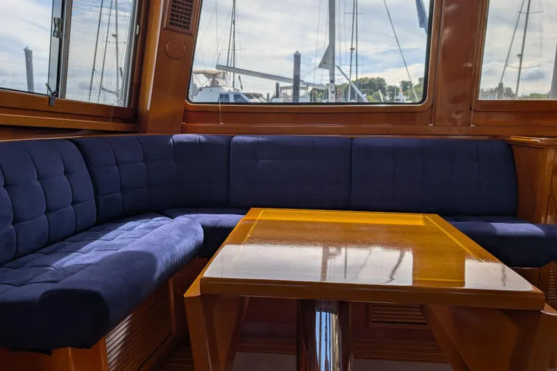 Slide: The Image of Interior of 2006 Grand Banks 49 Eastbay SX with blue seating and wooden table. - 24