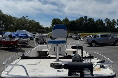 Slide: The Image of 2006 Carolina Skiff 178 DLX boat in parking lot, surrounded by vehicles and trees. - 2