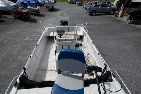 Slide: The Image of 2006 Carolina Skiff 178 DLX boat with blue and white seating, parked in a marina. - 6