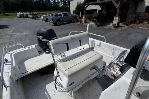 Slide: The Image of 2006 Carolina Skiff 178 DLX boat with Suzuki outboard motor in a parking area. - 9