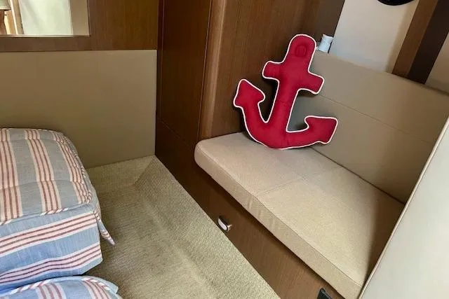 Slide: The Image of Interior of 2014 Sea Ray 350 Sundancer with anchor pillow and striped bedding. - 19