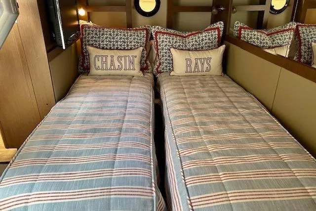 Slide: The Image of Interior of 2014 Sea Ray 350 Sundancer with twin beds and nautical-themed pillows. - 20