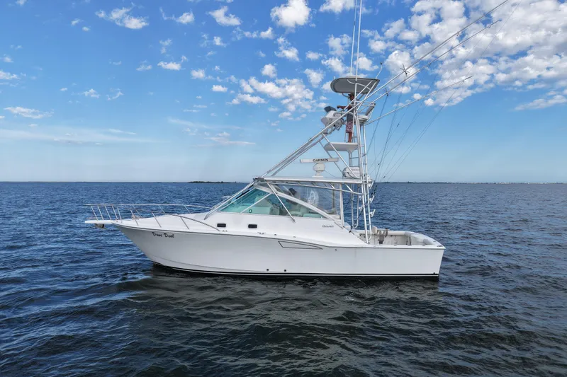 Slide: The Image of 2001 Cabo 35 Express boat on open water under a clear blue sky. - 1