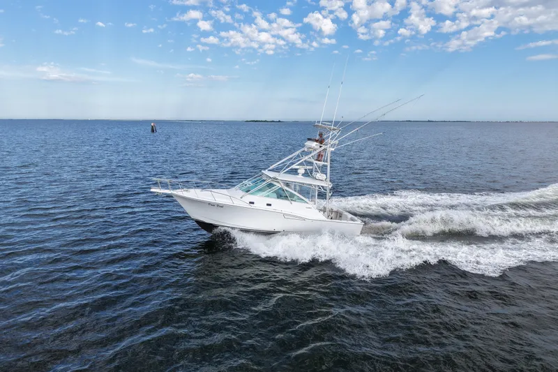 Slide: The Image of 2001 Cabo 35 Express boat cruising on open water under a clear sky. - 15