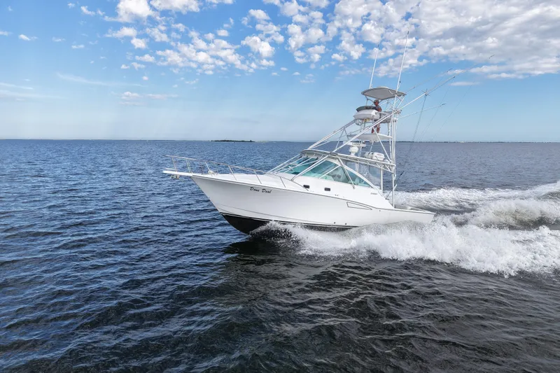Slide: The Image of 2001 Cabo 35 Express boat cruising on open water under a partly cloudy sky. - 16