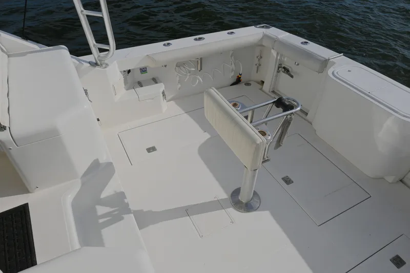 Slide: The Image of 2001 Cabo 35 Express boat deck with fishing rod holders and storage compartments. - 19