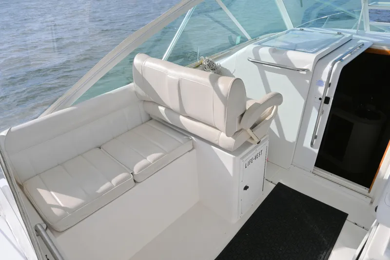 Slide: The Image of 2001 Cabo 35 Express boat interior with white seating and life vest storage. - 25