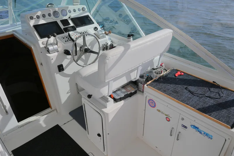 Slide: The Image of 2001 Cabo 35 Express boat cockpit with steering wheel and control panel. - 26