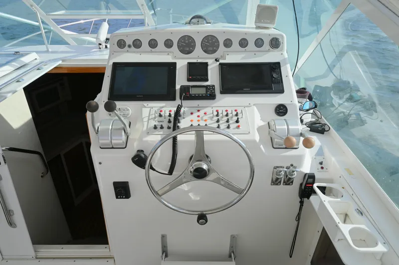 Slide: The Image of Cockpit of 2001 Cabo 35 Express boat with steering wheel and navigation controls. - 28