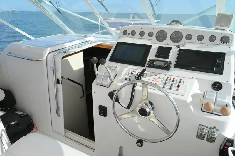 Slide: The Image of 2001 Cabo 35 Express boat helm with navigation instruments and steering wheel. - 29