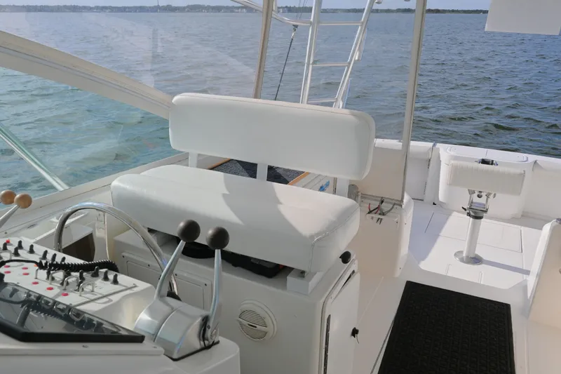 Slide: The Image of 2001 Cabo 35 Express boat cockpit with steering controls and seating, overlooking the water. - 31