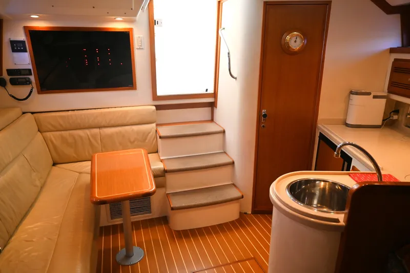 Slide: The Image of Interior of 2001 Cabo 35 Express yacht with seating, table, and kitchenette. - 43