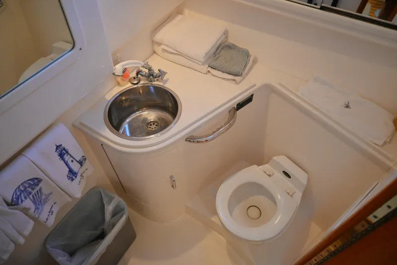 Slide: The Image of 2001 Cabo 35 Express boat bathroom with sink, toilet, and towels. - 49