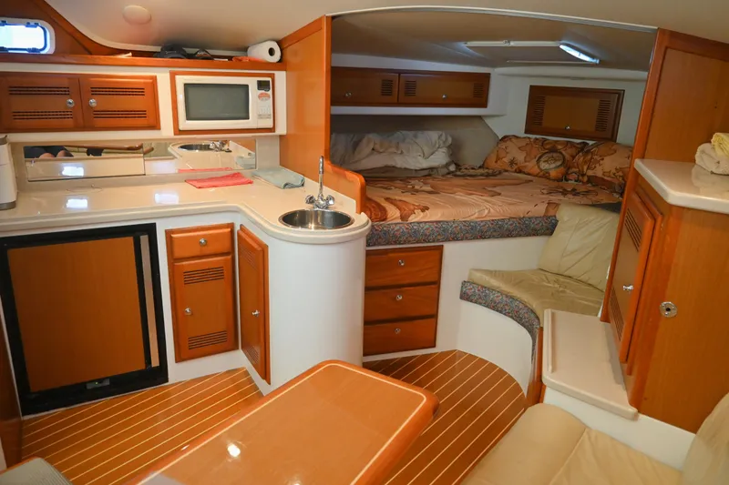 Slide: The Image of Interior of 2001 Cabo 35 Express boat with kitchenette and cozy sleeping area. - 50