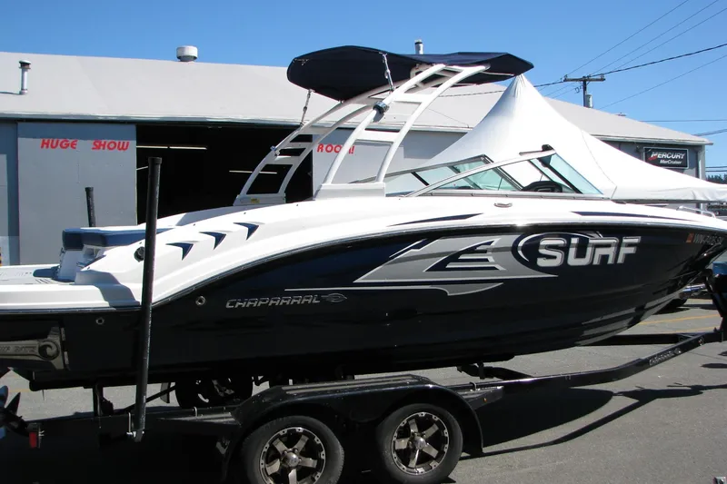 Slide: The Image of 2020 Chaparral 23 Surf boat on trailer, displayed outdoors under clear blue sky. - 2