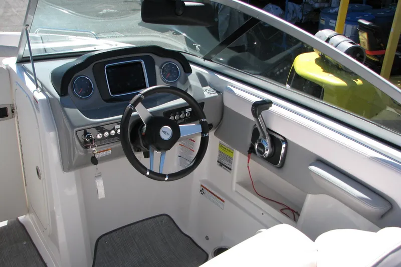 Slide: The Image of 2020 Chaparral 23 Surf boat dashboard with steering wheel and control panel. - 7