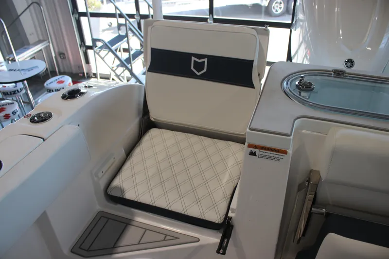 Slide: The Image of 2026 Sea Fox 328 Commander boat seat with white and navy upholstery in a showroom. - 27